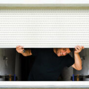 man with hands holds sunblind on pvc window