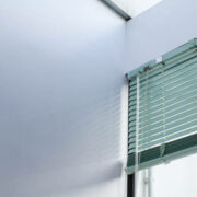 Aluminum window rolling blind. White plastic window with blinds close-up. Interior design.