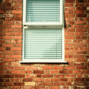 Architecture detail. Old brick wall with window blinds. Outdoor